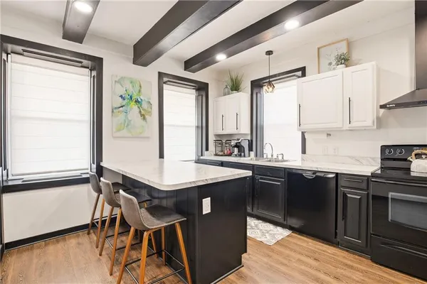a kitchen with stainless steel appliances granite countertop wooden floors and sink