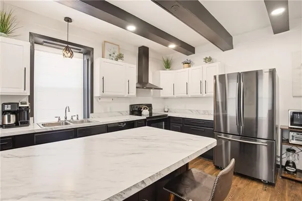 a kitchen with stainless steel appliances a refrigerator and a stove top oven