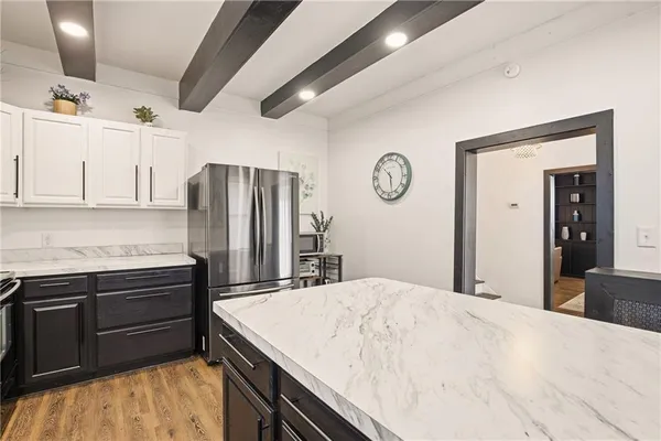 a kitchen with stainless steel appliances kitchen island granite countertop a refrigerator and a stove top oven