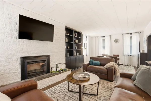 a living room with furniture a flat screen tv and a fireplace
