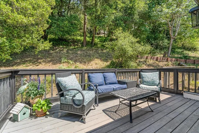 a view of a balcony with wooden floor and outdoor seating