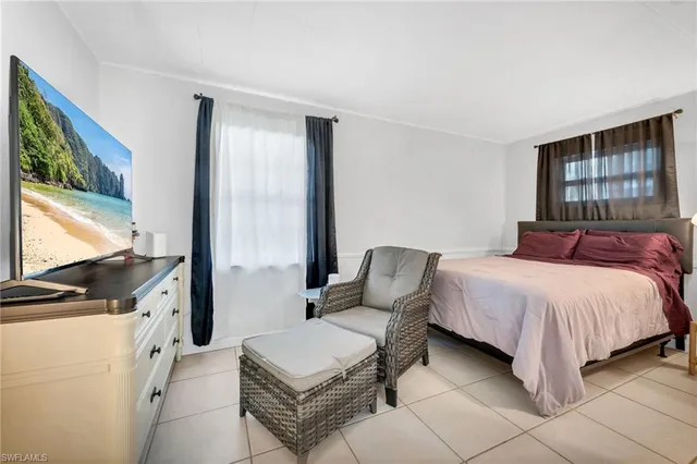 a spacious bedroom with a bed and glass window