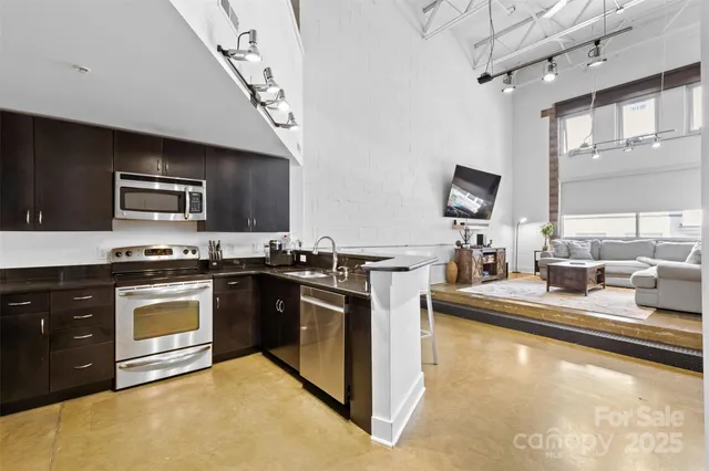 a kitchen with stainless steel appliances granite countertop a stove a sink and a microwave