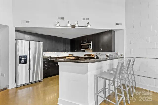 a kitchen with stainless steel appliances a sink and a refrigerator