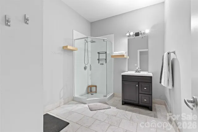 a spacious bathroom with a shower sink and a mirror