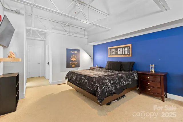 a spacious bedroom with a bed and a flat screen tv