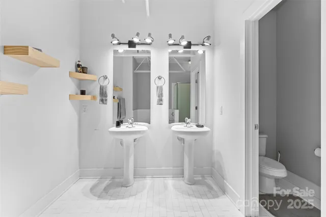 a bathroom with a double vanity sink toilet and shower