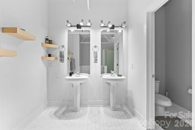 a bathroom with a double vanity sink toilet and shower