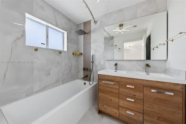 a bathroom with a tub double vanity sink and mirror