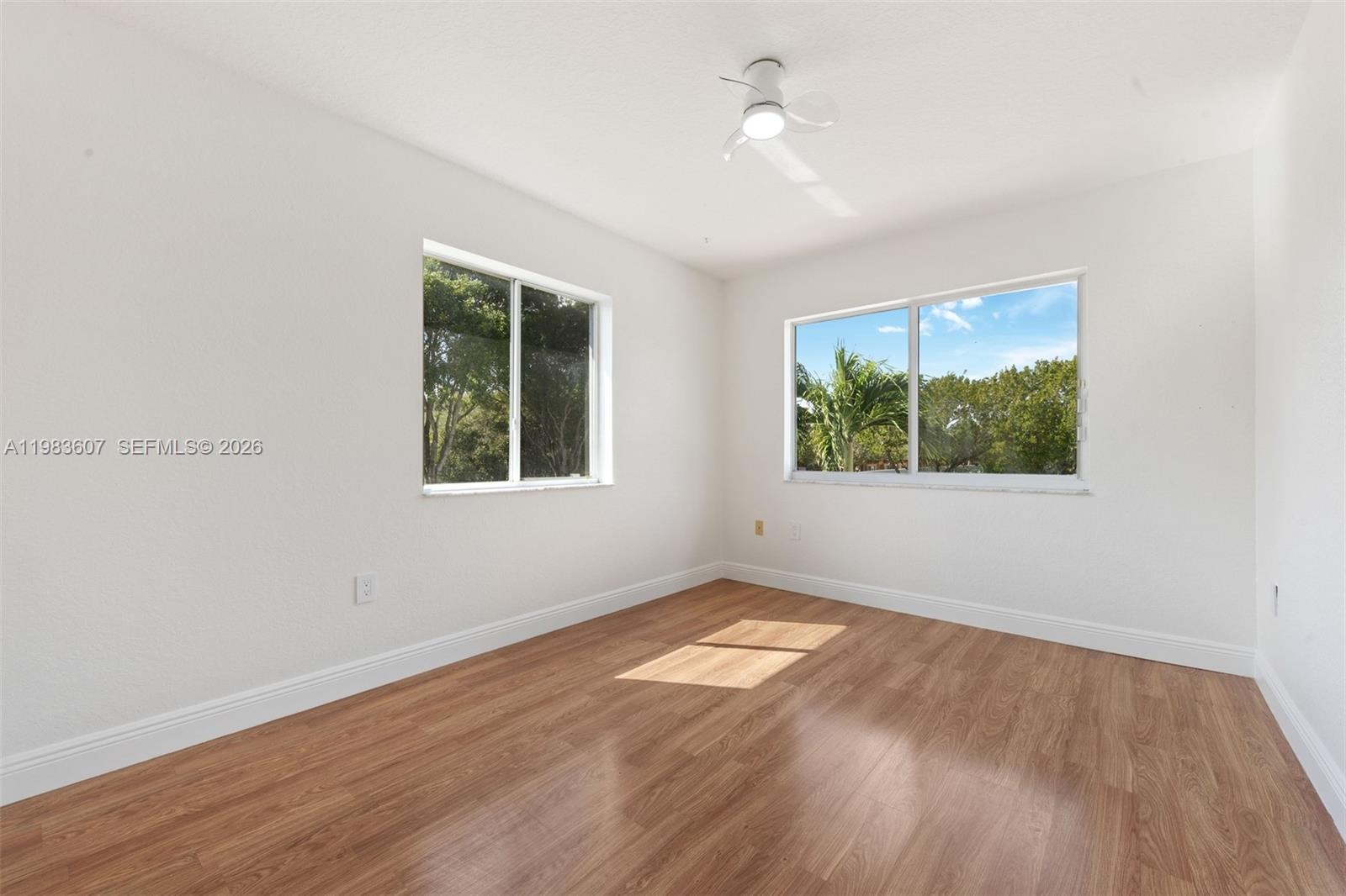2897 Southwest 129th Way Miramar, FL 33027 - Photo 16 of 22 an empty room with wooden floor ceiling fan and windows