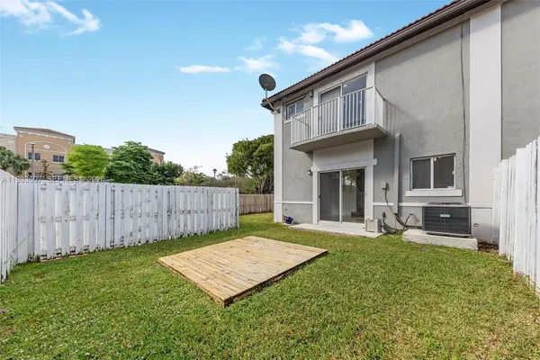 a view of a house with a yard and wooden fence
