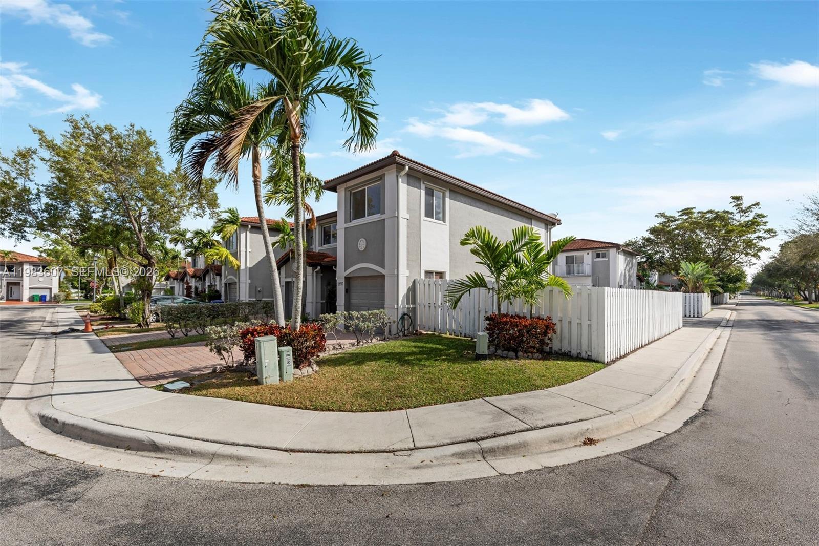 2897 Southwest 129th Way Miramar, FL 33027 - Photo 2 of 22 a view of a white house with a yard and potted plants