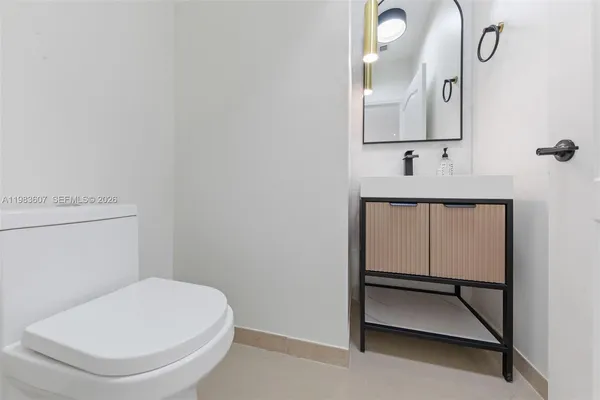 a bathroom with a toilet a sink and mirror