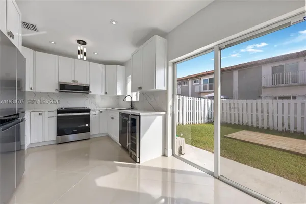 a kitchen with kitchen island granite countertop a stove a sink and a microwave