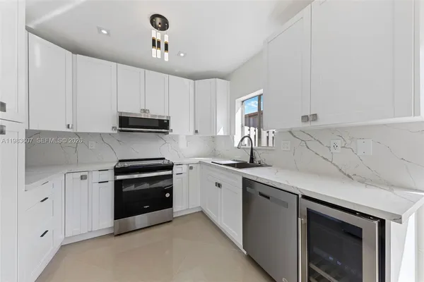 a kitchen with stainless steel appliances granite countertop a sink and a stove