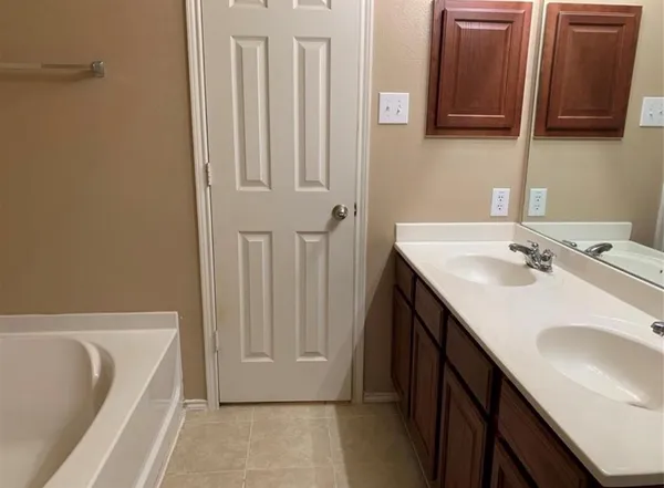 a bathroom with a sink a bathtub and a mirror