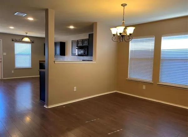 a view of a room with wooden floor and windows