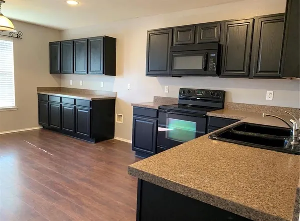 a kitchen with stainless steel appliances kitchen island granite countertop a stove a sink and a microwave