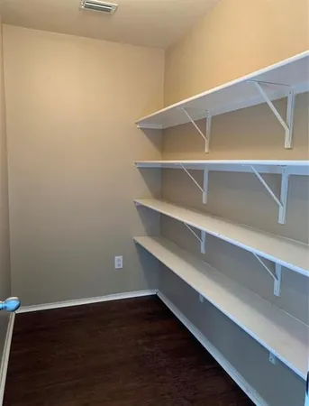 a view of walk in closet with empty racks