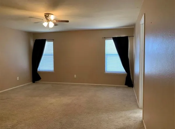 an empty room with a window and a ceiling fan