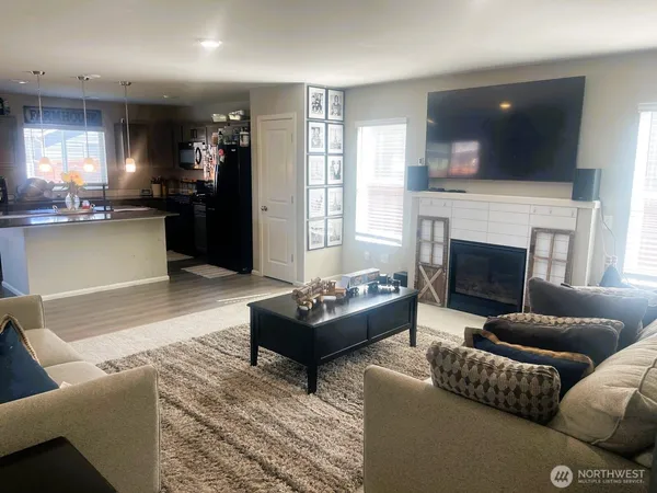 a living room with furniture a flat screen tv and a fireplace