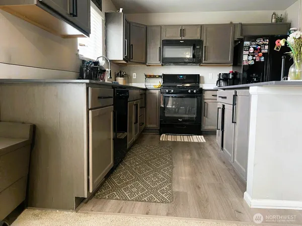 a kitchen with stainless steel appliances granite countertop a refrigerator a stove top oven a sink and dishwasher