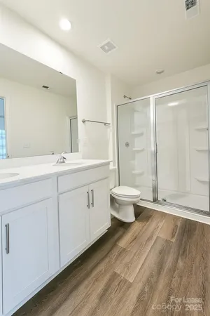 a bathroom with a double vanity sink toilet and shower