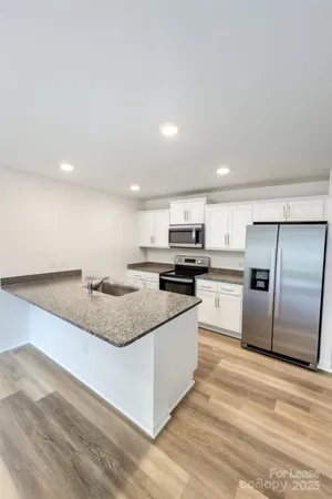 a large kitchen with a stove a refrigerator and a sink