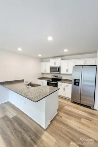 a large kitchen with a stove a refrigerator and a sink