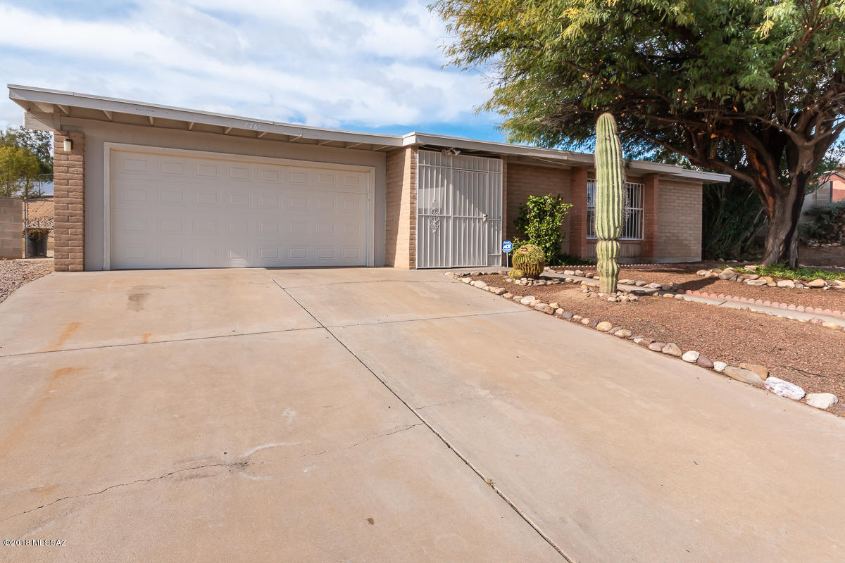 7761 North Rasmussen Avenue Tucson, AZ 85741 - Photo 2 of 23 a backyard of a house with table and chairs under an umbrella