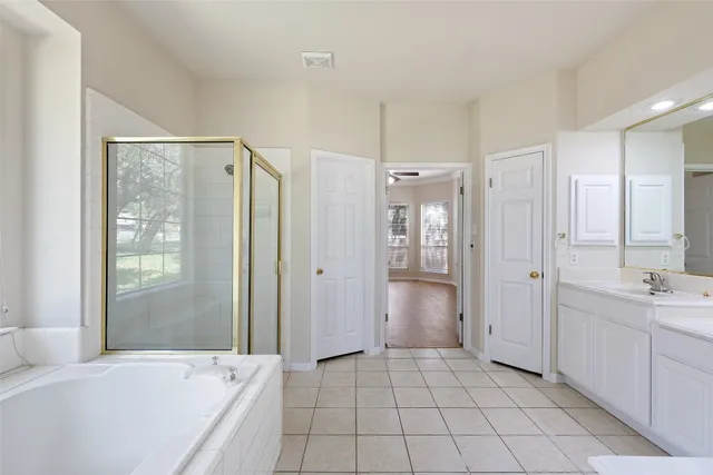 a spacious bathroom with a mirror a shower and a bathtub