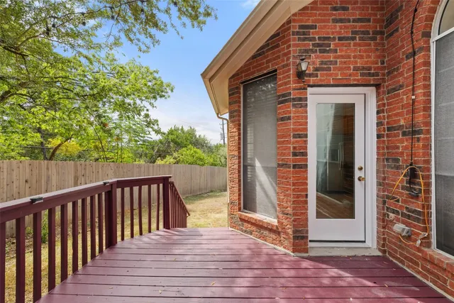 a view of a brick house with wooden floor and a bench