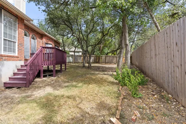 a view of a backyard with wooden fence