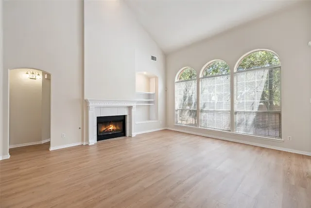 a view of empty room with wooden floor and fireplace