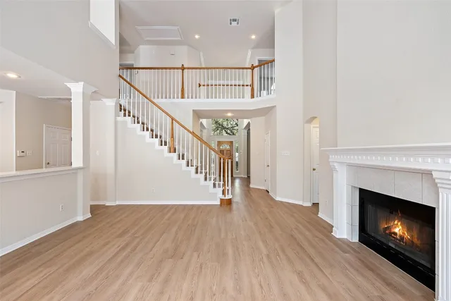 a view of an empty room with wooden floor fire place