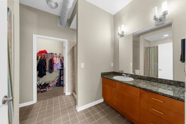 a bedroom with a bed and dresser with mirror