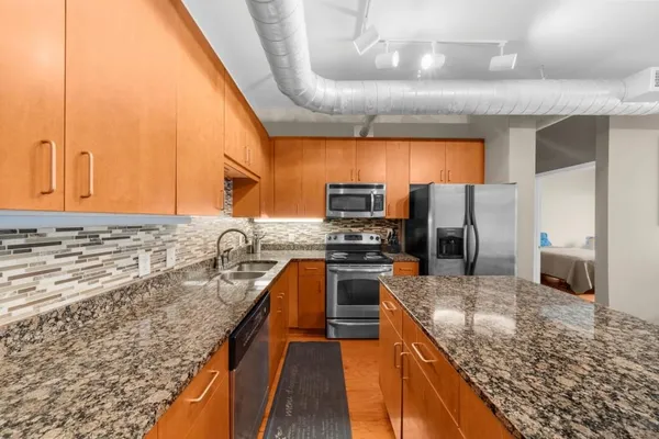 a kitchen with stainless steel appliances granite countertop a sink stove and refrigerator