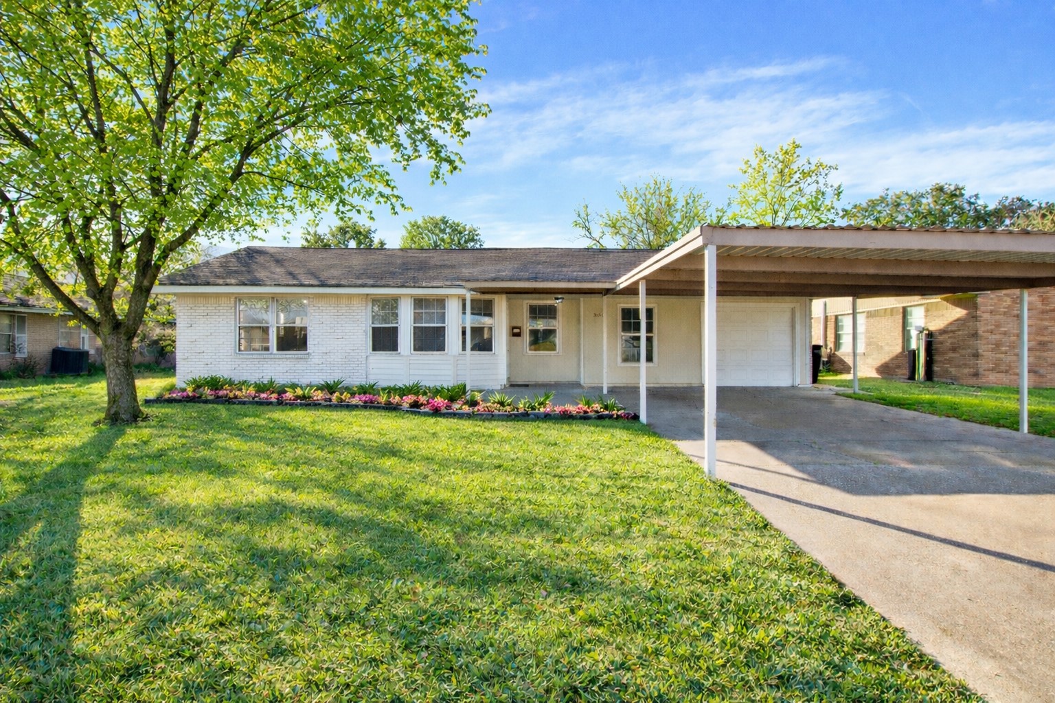 506 Edgebrook Drive Houston, TX 77034 - Photo 1 of 18 Charming single-story home with a brick exterior, featuring a spacious front lawn and a large carport. The property is accented by mature trees to give it a charming curb appeal.