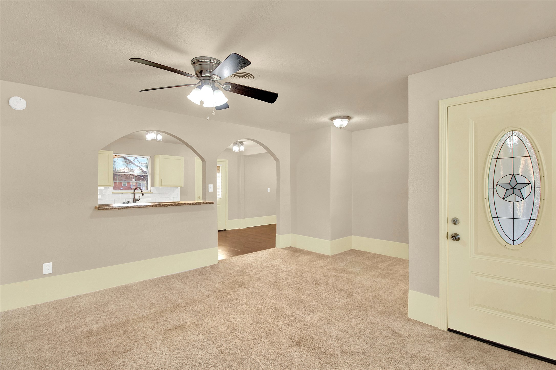 506 Edgebrook Drive Houston, TX 77034 - Photo 4 of 18 Features include additional stylish archways leading to adjacent areas, and a view into the kitchen with a bar counter. The entry door has a decorative glass insert, adding charm to the space.