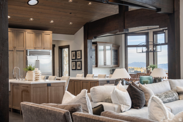 9156 Forest Road, Unit 24 Heber City, UT 84036 - Photo 8 of 42 Open-concept interior featuring exposed wood beams, a kitchen island with seating, stainless steel refrigerator, recessed lighting, and large windows