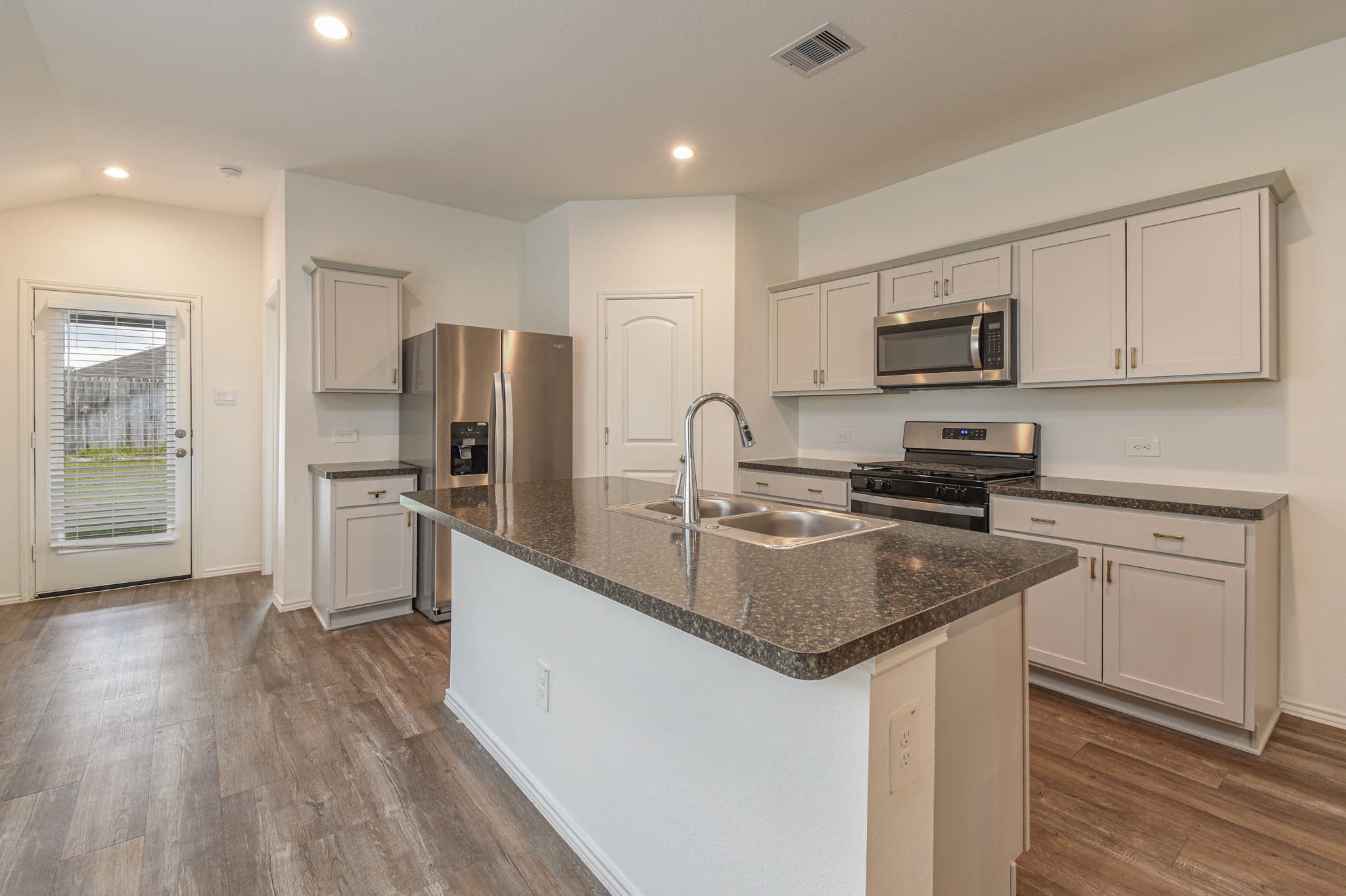 5423 Wyndham Ridge Ln Spring Spring, TX 77373 - Photo 12 of 23 a kitchen with kitchen island granite countertop a sink appliances cabinets and counter space