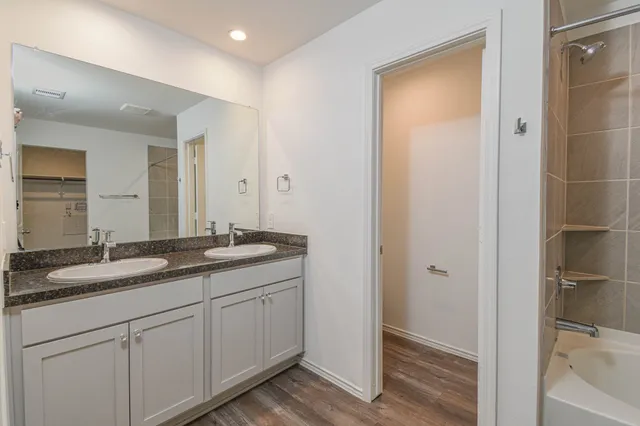 a bathroom with a granite countertop sink and mirror