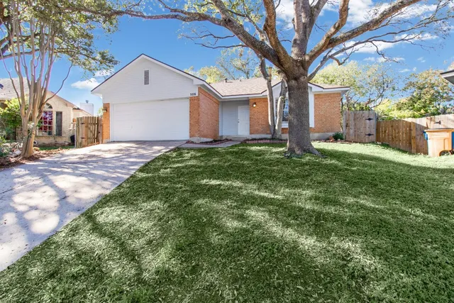 a white house that has a tree in front of it