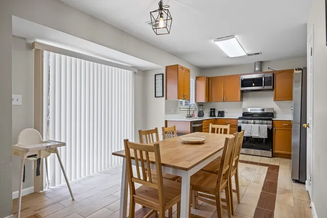 a kitchen with a table chairs refrigerator and microwave