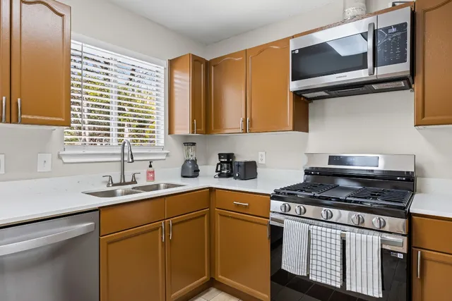 a kitchen with stainless steel appliances granite countertop a stove a sink and a refrigerator