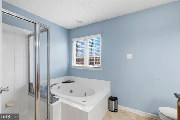 a bathroom with a tub a sink and a window