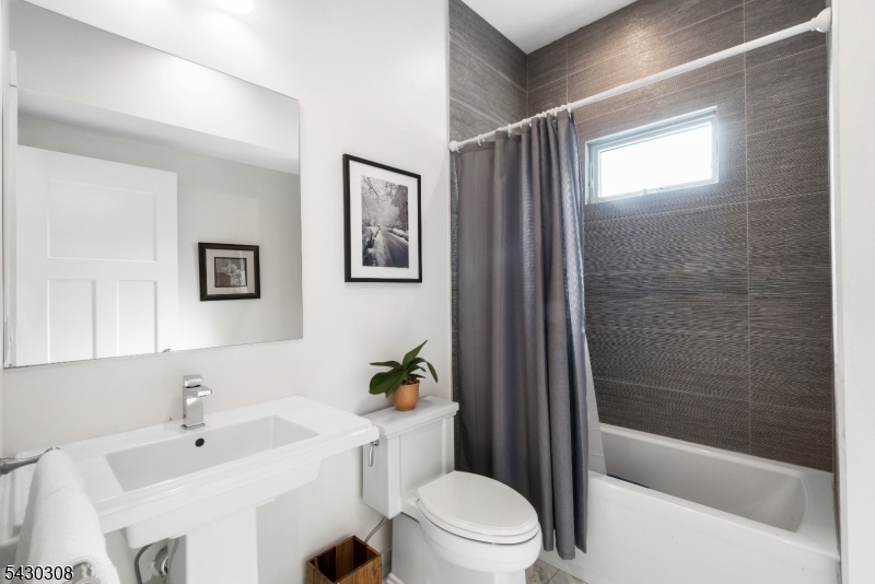 19 78th Street North Bergen, NJ 07047 - Photo 18 of 42 a bathroom with a bathtub shower sink mirror and toilet