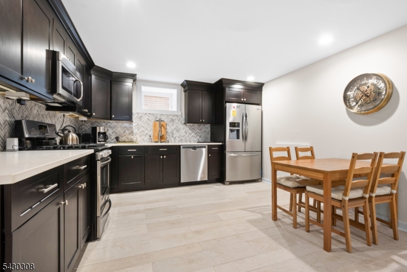 19 78th Street North Bergen, NJ 07047 - Photo 28 of 42 a kitchen with stainless steel appliances granite countertop a sink counter space and cabinets