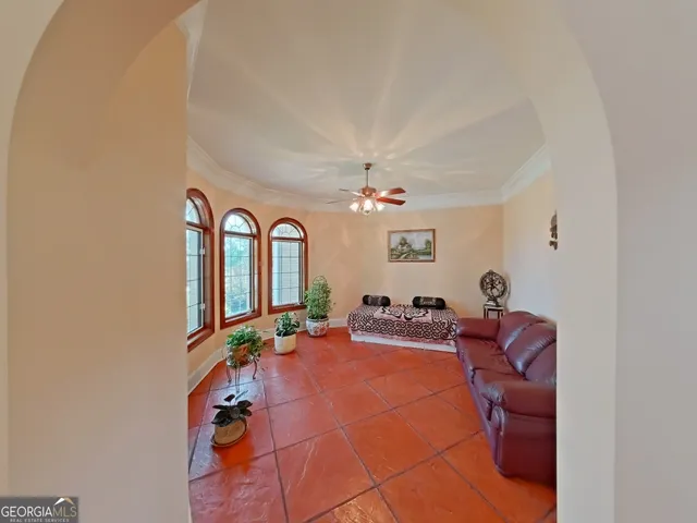 a living room with furniture a chandelier fan and a window