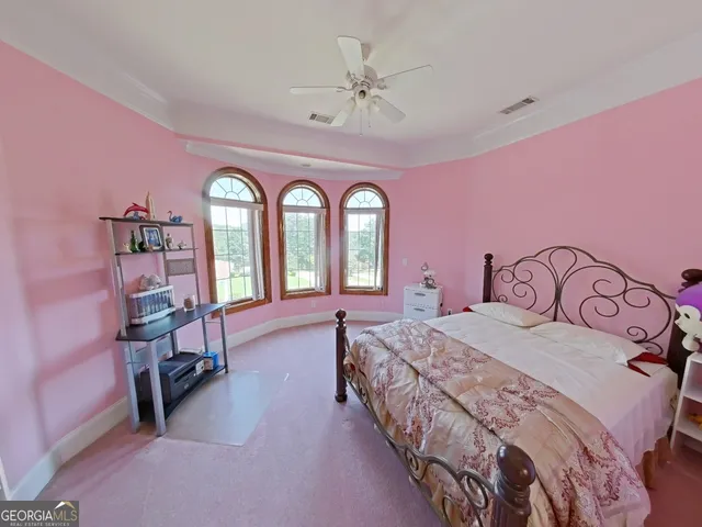 a bedroom with a bed a chandelier and dresser